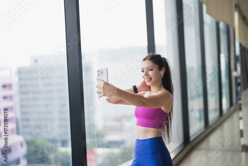 Free Download Healthy Young Hispanic Gen Z Woman in Sportswear Using Smartphone to Create Fitness Trends on Social Media. - GFXLoad