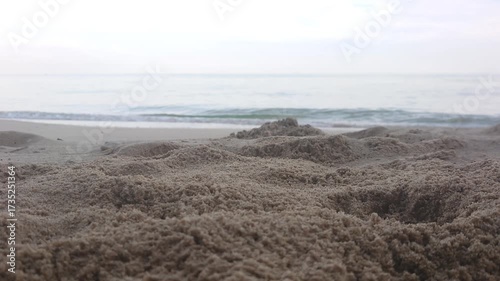 Calm sea waves rolling on sandy beach shore in the morning, relaxing ocean nature footage for travel, vacation, and background use