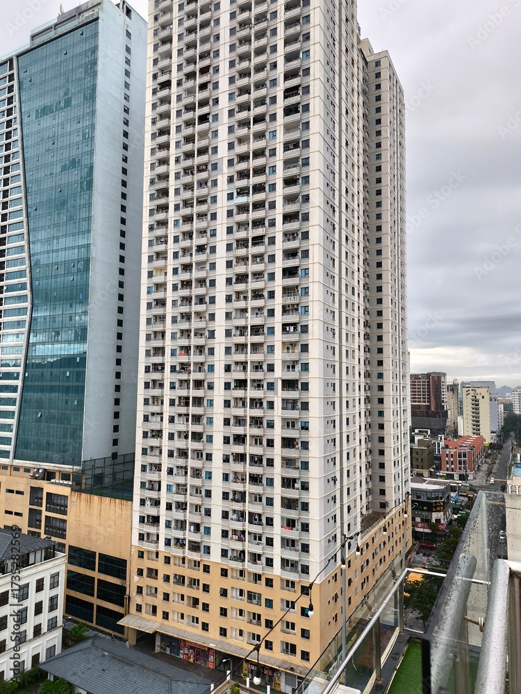 Obraz premium Two Modern High-Rise Buildings Against Cloudy Sky