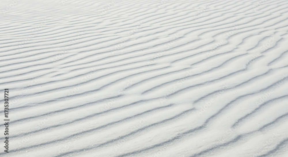 Obraz premium White sand texture background with wave pattern, top view natural beach surface design.