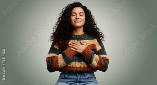 Serene Reflection: A woman with closed eyes and a gentle smile radiates peace, placing her hands over her heart in a gesture of self-love and mindfulness. 