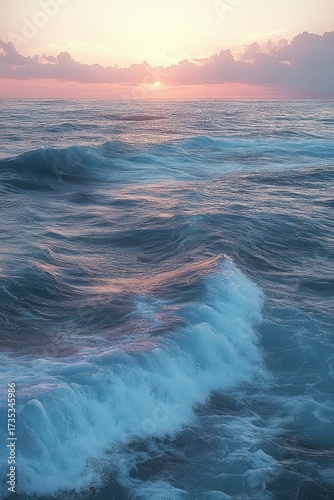 Serene ocean waves under a soft pastel sunset sky with scattered clouds reflecting pink and purple hues on the water's surface