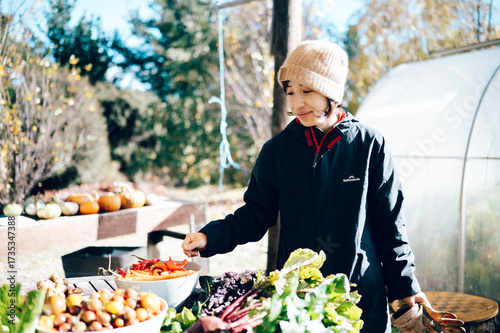 Woman at organic farm market with fresh vegetables in Wanaka, New Zealand