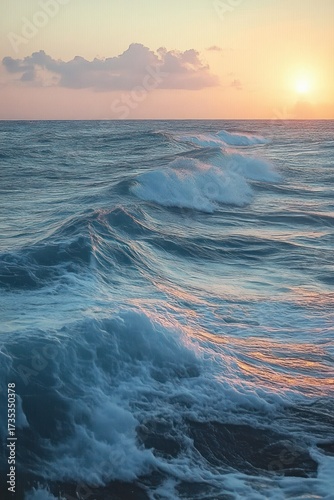 Calm ocean waves gently rolling under a serene pastel sunset sky with soft clouds on the horizon