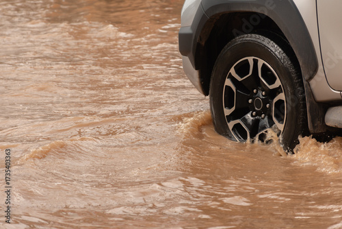 Muddy rain from a heavy rainy season flooded main roads connecting the district, making it difficult for cars to pass through and causing engine failures, in motion, car insurance concept, in motion.