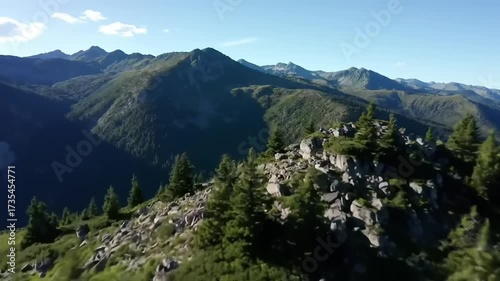 Aerial view of scenic mountain landscape with lush green vegetation under a clear blue sky during daylight