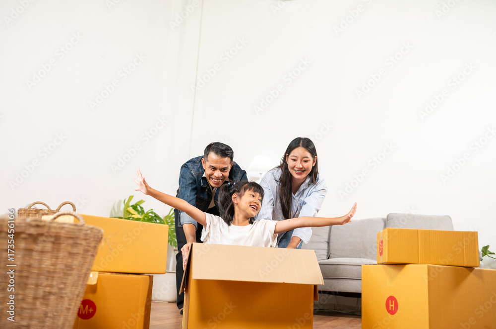 © somchai20162516 - Family's New Chapter: A happy family embraces the excitement of moving into their new home, symbolizing a fresh start, filled with joy and togetherness as they unpack their belongings.
