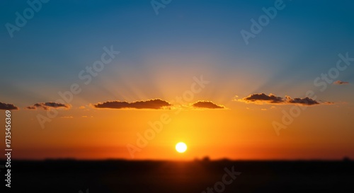 Vibrant sunset landscape with dramatic light and clouds over a silhouette horizon suitable for various applications