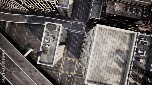 This aerial view reveals a bustling urban scene with intersecting streets and tall buildings. The sunlight casts shadows across the rooftops, highlighting the citys architecture and layout.