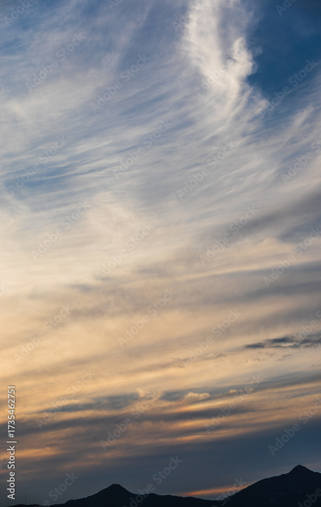 Fototapeta premium Layered Evening Clouds Above Dark Mountain Silhouettes