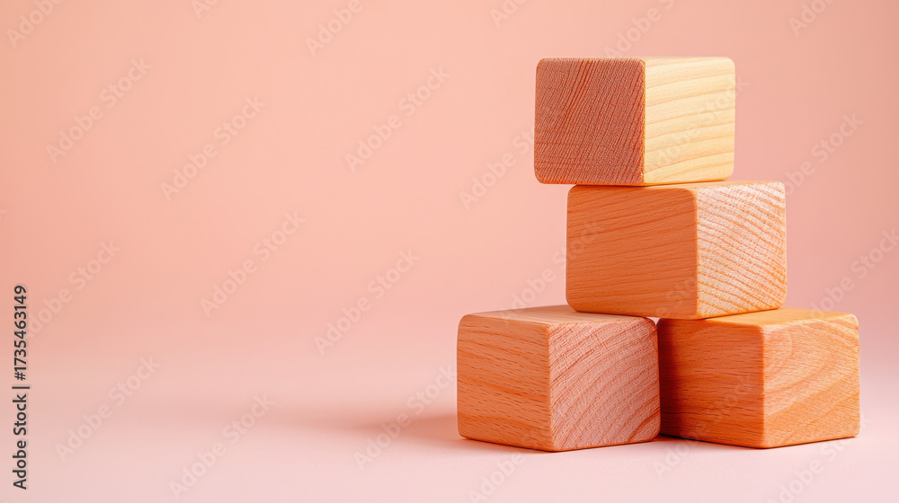 Obraz premium Stacked wooden blocks in soft peach tones create playful and inviting atmosphere, perfect for children activities or educational settings
