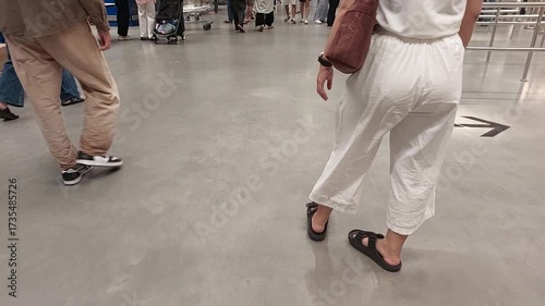 People Walking Indoors on Shiny Floor in Public Space