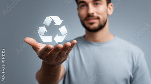 Young man demonstrating recycling concept with floating recycle symbol in hand, promoting sustainable living and environmental awareness