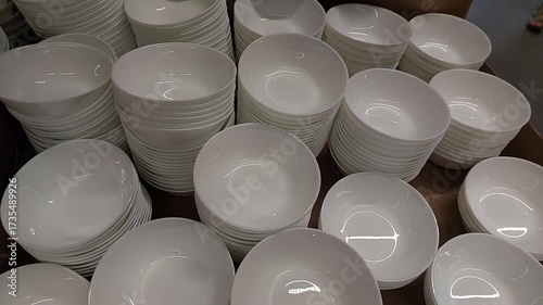 Close-up video of neatly stacked white ceramic bowls on display in a store. The footage highlights the clean and minimalistic design of the bowls, showcasing their smooth surface and glossy finish.