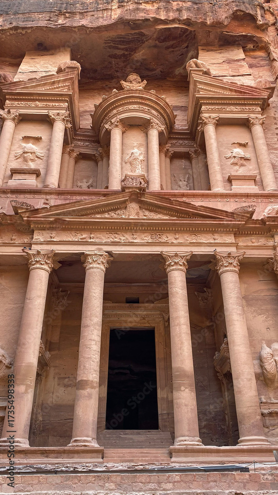 Obraz premium The iconic Al-Khazneh (The Treasury) in Petra, Jordan, a magnificent Nabataean tomb carved directly into the towering sandstone cliff.