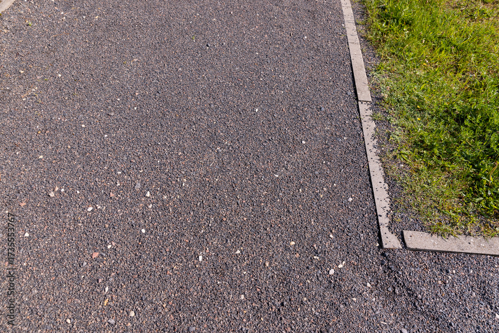 Obraz premium a narrow walking path in the park made of finely crushed rubble, not a wide path for pedestrians to walk in the park in sunny weather