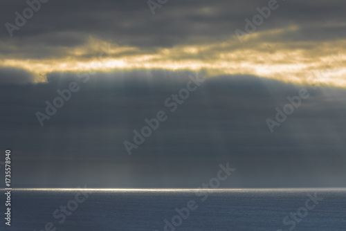 Sunbeams streaming through fog opening in the Pacific Ocean at Big Sur, California.
