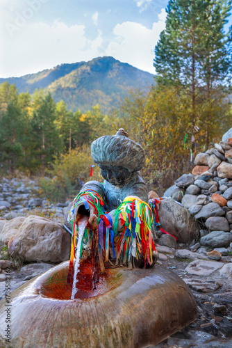 A spring of beneficial mineral water in the form of a sculpture of a Buryat boy. Arshan, Buryatia, Kyngyrga River