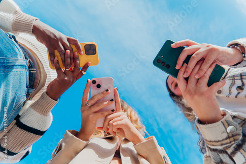 Diverse young friends actively engaging with smartphones. Capturing moments and sharing digital content. Representing youth culture. Social media connection