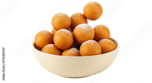 Delicious loukoumades in a bowl isolated on white, traditional Greek honey donuts with powdered sugar for dessert and sweet treat