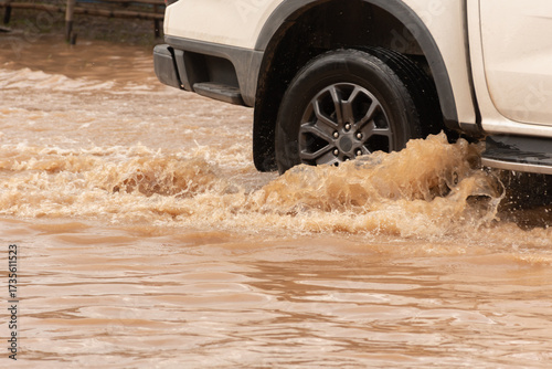 Muddy rain from a heavy rainy season flooded main roads connecting the district, making it difficult for cars to pass through and causing engine failures, in motion, car insurance concept, in motion.