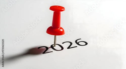 Marking the future: A red pin highlighting the year 2026 on a clean white surface