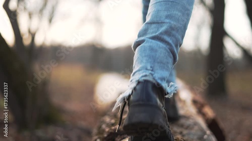 Wallpaper Mural Walk on log balancing with boot, denim leg and ankle visible, steady hiking step along forest trail, nature scene with closeup of sole on bark, emphasis on balance and calm outdoor movement. Torontodigital.ca