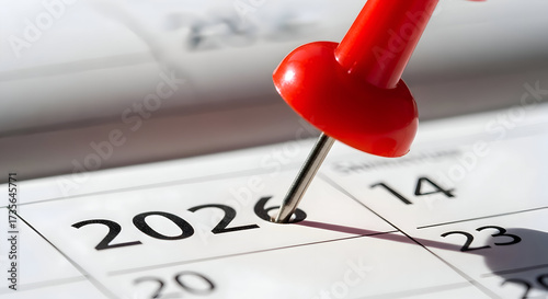 A close-up of a calendar showing the year 2026 marked with a red pushpin signifying an important