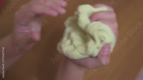Little girl playing with a yellow slime. Selective focus.
