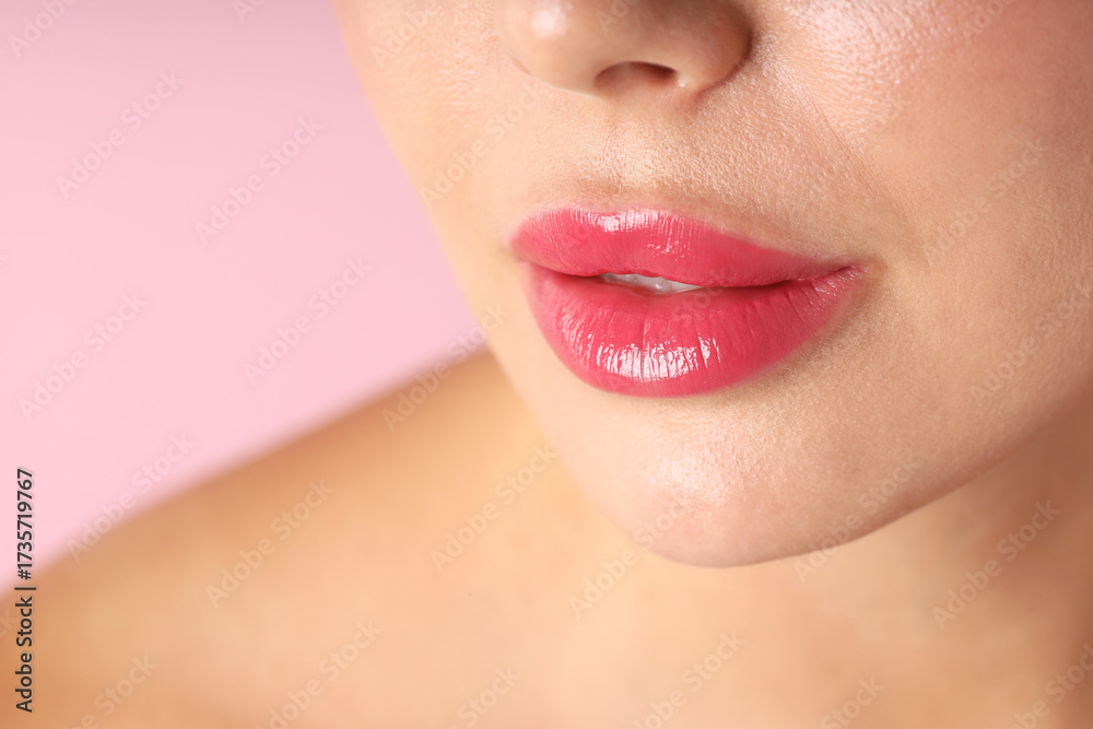 Obraz premium Woman with beautiful lipstick on her lips against pink background, macro view