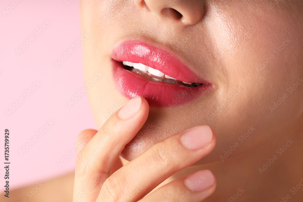 Obraz premium Woman with beautiful lipstick on her lips against pink background, macro view