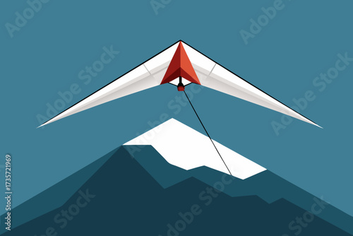 Hang glider soaring above snow capped mountains against a clear blue sky