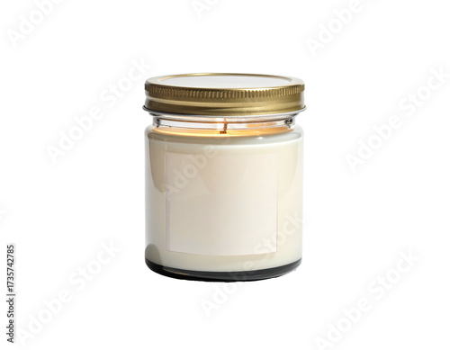 A lit candle in a glass jar, gold lid, blank label, isolated on black