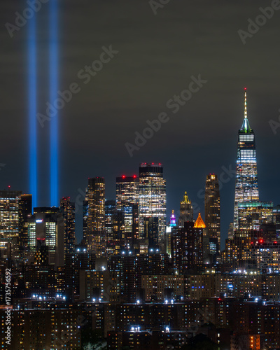 Wallpaper Mural Tribute in Light. View of luminous twin beams pierce the night sky over a sprawling cityscape, reflecting off modern skyscrapers in solemn remembrance of 9-11, New York, New York, United States. Torontodigital.ca