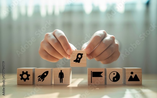 A person's hands build a strategic business plan with wooden blocks, representing the concept of growth, vision, and a successful rocket launch