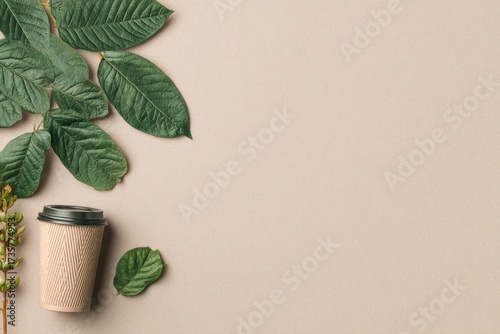 A beige disposable coffee cup sits amongst vibrant green leaves on a neutral backdrop, creating a serene and eco-conscious image.