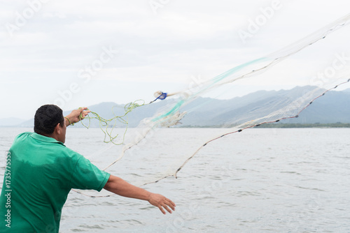 Fisherman throwing cast net for traditional fishing in sea