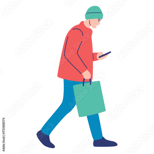 A young man in warm winter clothing walking with a shopping bag while looking down and using his smartphone, representing a modern urban lifestyle