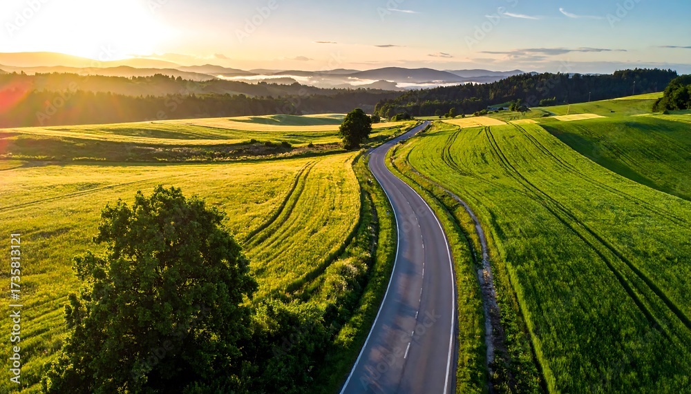 Naklejka premium Aerial View of a Winding Country Road at Sunrise.