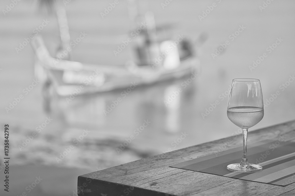 Obraz premium glass of cold white wine on the summer seashore by the water, relaxing by the water, a gentle background of soft color
