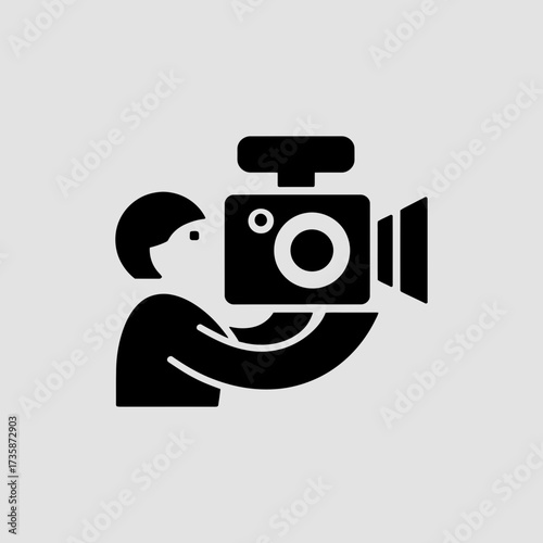 Vector illustration of a person filming with a video camera versatile scalable graphics silhouette