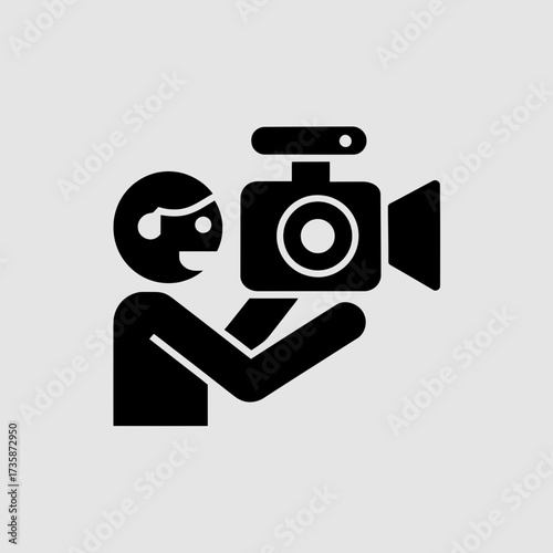 Black and white illustration of a person holding a video camera icon vector graphic silhouette
