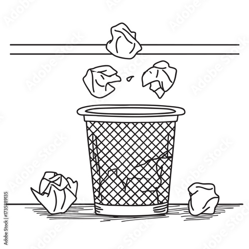 A wastebasket under a table with crumpled notes and wrappers