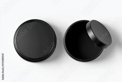 Two black round cosmetic containers, one open