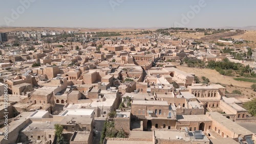 Aerial panning view of Midyat old city in Mardin Province, showing stone houses, narrow streets, historic buildings yellow milestone traditional buildings