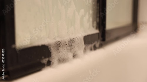 De la mousse qui dégouline d'une porte dans une salle de bain.