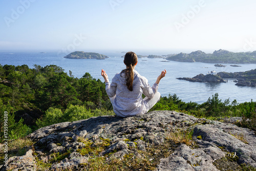 Woman sitting on rock and looking at sea view, Norway