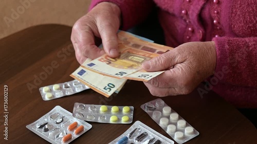 Granny counts euro banknotes while preparing to buy new medicine. An elderly woman counts her euro banknotes as she looks at almost empty pill blisters, preparing to buy more medicine