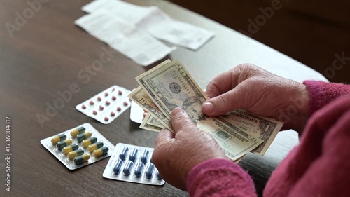 Granny counts her money after buying medicine at the local pharmacy. An elderly woman counts her dollars after purchasing essential medicine, carefully checking her expenses