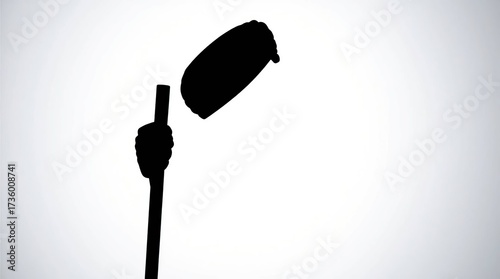 Silhouette hand holding stick with object.